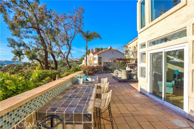 Your new backyard has outdoor countertop seating and an area to accommodate a bbq adjacent to the barstools.