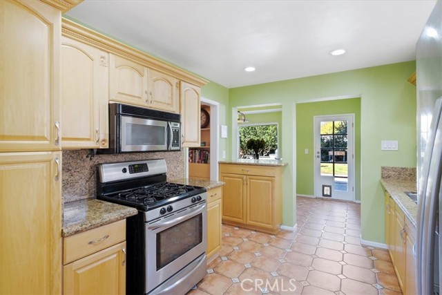 Updated kitchen with granite countertops, stainless appliances. Note the stone floors with decorative insets.