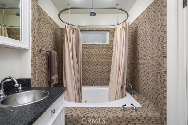 Primary suite bathroom spa tub and rainfall shower