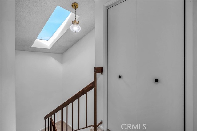 Stairs leading to the bedrooms with a skylight and a closet