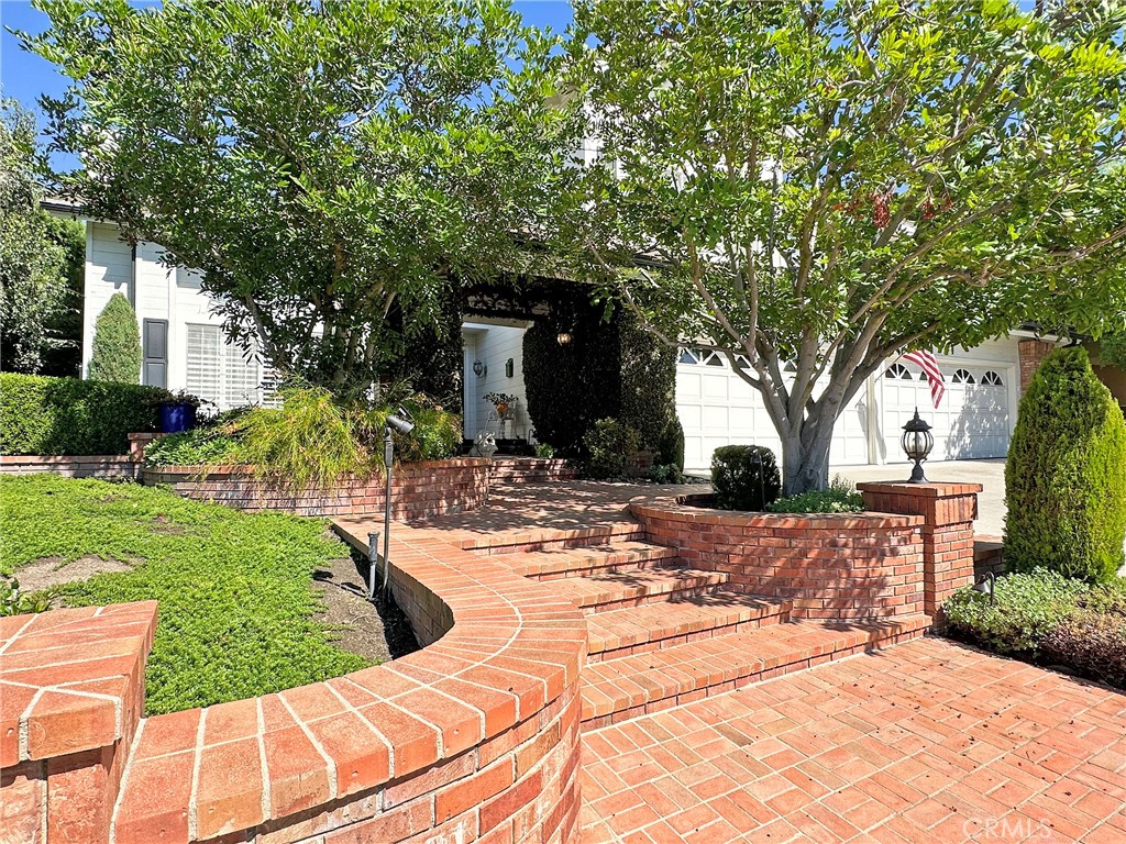 Enjoy the Grand and Lushly landscaped entrance to this Beautiful Country French inspired Home in the highly desirable GATED community of Canyon Crest Estates in Mission Viejo!  From the front door to the exquisite garden areas in the back yard with its Mountain VIEWS you will enjoy relaxing under the gable-roofed patio and the County Charm this property has to offer including superb PRIVACY and a 4 CAR GARAGE! The living room features a grand fireplace that serves as the focal point.  Towering cathedral ceilings create an air of spaciousness and abundant natural lighting highlighting the exquisite details of the room that flow into a Large Elegant dining room with a wall of French Doors and Windows that opens to a lush garden. The kitchen is a culinary haven that integrates with a charming kitchen nook and is graced by a bay window that offers a delightful view.  The kitchen overlooks the adjacent family room featuring French doors that open up to the serene outdoors.  A built-in bar and fireplace add a  touch of coziness, making it a perfect spot for intimate gatherings on chilly evenings.  Stepping through the French doors you find yourself on a picturesque, gable-roofed patio to relax and dine while enjoying the country gardens and the majestic mountain views.  The combination of the gourmet kitchen its connection to the family room and the seamless transition to the inviting outdoor patio makes this area a true sanctuary for both culinary delights and leisurely moments of enjoyment. Laundry Room with sink offers outdoor access and a powder room complete the downstairs.  The Beautiful wood stair case leads you to the Master Ensuite with separate tub and shower, walk-in closet and separate water closet. 3 Additional Bedrooms and a bathroom offering porcelain flooring, dual sinks, separate water closet with tub/shower finishes the upstairs. Custom Shutters Throughout.  Garage offers a 16' workbench and lots of storage space. This first time on the market home shows Pride of Ownership.  Enjoy the Club House, Olympic size pools, giant jacuzzi spa, fully equipped gym, sport courts including tennis/pickleball courts, billiard room, library and full on reception room with kitchen for family events.  Enjoy Lake Mission Viejo with its Summer Concerts, Water Activities, Boat Rentals, Fishing (Catch/Release) and more.  Highly Rated School Area, close to Fwys, Toll Roads, Shopping and Dining.  A MUST SEE!!!