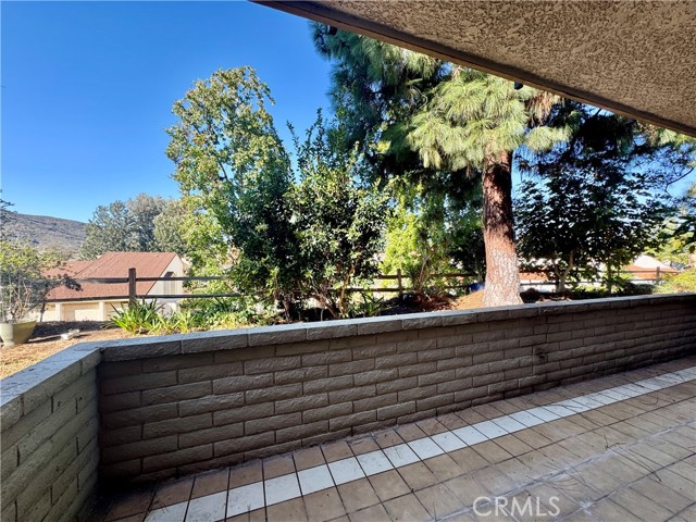 This private patio is a serene escape, surrounded by fruit trees and lush greenery, with scenic views of rolling hills—perfect for those who value tranquility and privacy.