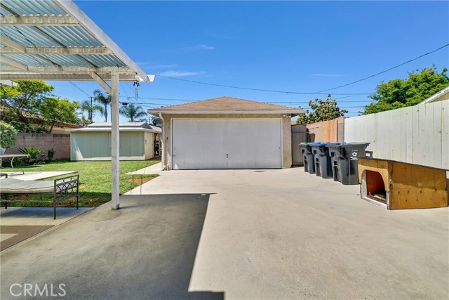 Backyard driveway behind fence. 2 Car detached garage