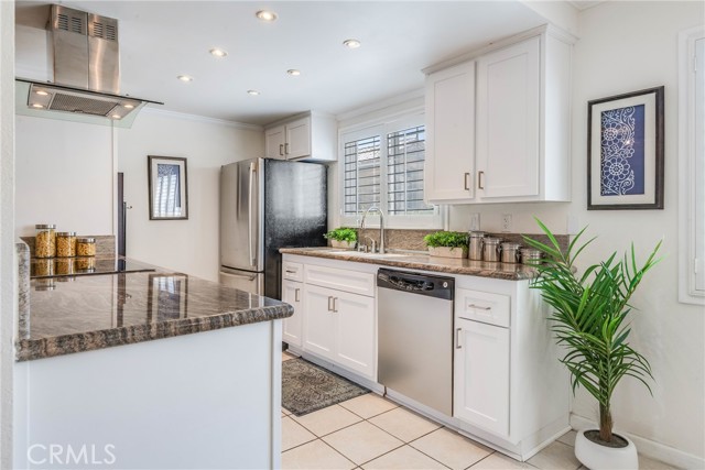 Bright and open remodeled kitchen featuring granite counters, stainless appliances, white shaker cabinets and plantation shutters.