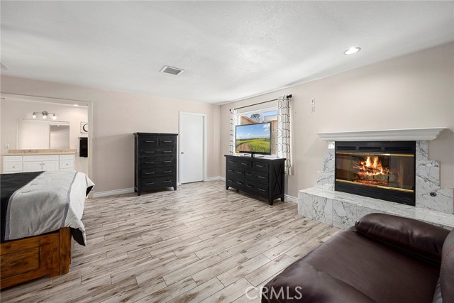 Large primary bedroom with fireplace and sitting area.