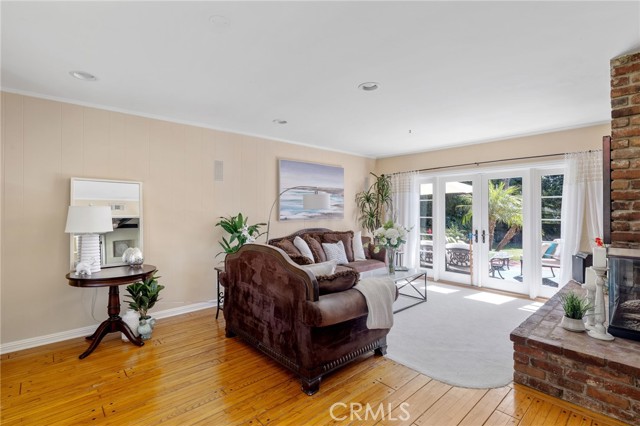 Large formal living room with doors to patio and yard.  Wood floors, smooth ceilings, recessed lighting add to the personality of this bright and airy space.