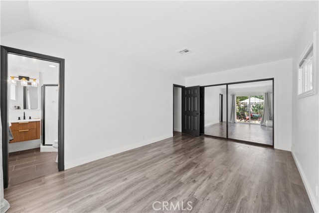 Primary bedroom w/mirrored closet doors and ensuite bathroom