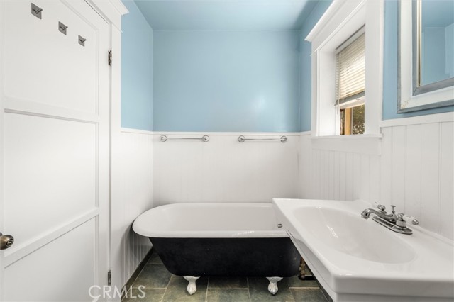 Upstairs bathroom. Clawfoot tub has a hand held wand style shower head.