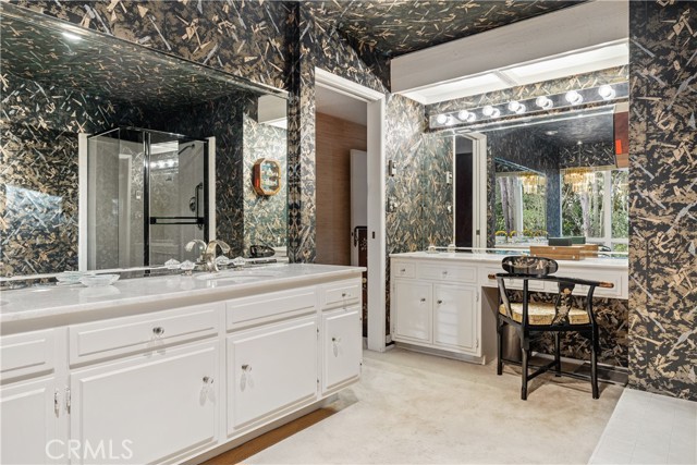 With dual-sinks, vanity table, large shower and large tub.