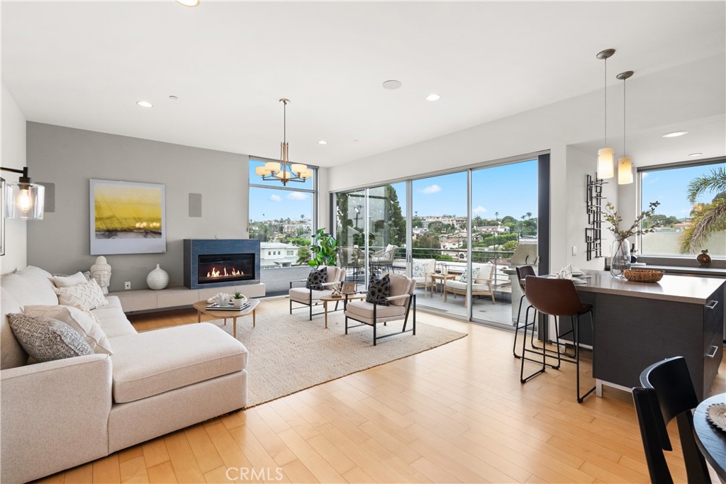 Discover luxury living in this award-winning modern townhome, now refreshed and professionally staged to highlight its stunning features. Nestled high above the prestigious Manhattan Beach Hill Section, away from the street, this home offers panoramic southwesterly treetop views, breathtaking sunsets, and cool ocean breezes from its floor-to-ceiling doors and windows. The piece de resistance is the upper level sun-filled great room, kitchen and dining area with a west-facing wall of windows that leads to an outdoor deck. It’s sunny and dramatic, creating an expansive feeling of openness due to the surrounding single-level structures—a rare find in Manhattan Beach—that lends privacy and a sense of ‘being above it all.” Also on this level is a versatile third bedroom. With its own separate entrance and full bath, it’s uniquely designed to serve as a professional office or guest quarters. It’s ideal for therapists, investment advisors, producers, architects, engineers, real estate professionals, social media consultants, or even your au pair. Work by day in a peaceful work environment overlooking the neighborhood, then step effortlessly into your beautiful living spaces. The mid-level boasts two extra large bedrooms with en-suite baths and a laundry room. The primary suite opens to a spacious deck and includes a walk-in closet, sleek bath with a double vanity, shower with rain head and body sprayers, and a jetted tub. On the lower level is the 2 car garage with direct access, storage and guest parking. Located within a short walk to the beach, downtown Manhattan Beach, and the iconic Manhattan Beach Pier, this home offers easy access to the ultimate SoCal beach lifestyle. Also nearby are neighborhood favorites such as Two Guns Espresso, O-Sho Sushi, El Gringo, Gelson’s Market and Target. Inspired by Dutch Artist Piet Mondrian, this mixed-use property was ahead of its time and received a Design Award from AIA Long Beach/South Bay. It features clean lines, high ceilings, and a floating staircase. Finishes include Caesarstone in the kitchen and baths, hardwood floors, stainless steel Jenn-Air and KitchenAid appliances, Grohe fixtures, Pedini Italian cabinetry, blackout shades in the primary bedroom, and a decorative gas fireplace. In addition to the 2-car garage, you have your own dedicated guest space and can block the garage. That’s a total of 4 car parking!  Common area amenities include a convenient elevator and a roof deck lounge space.