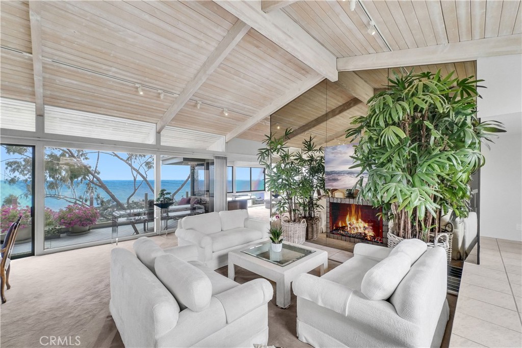A Rare Gem in North Laguna with Unmatched Ocean Views!

Opportunities like this are few and far between. A stunning home situated on a flat, quiet cul-de-sac in coveted North Laguna, offering unobstructed 180-degree ocean, coastline, and city views. This exceptional property blends casual coastal elegance with the relaxed charm of beachside living.

Enter through a beautifully landscaped courtyard featuring a rustic fountain designed by local artist Dan Skaggs, lush tropical foliage, and a serene ambiance that sets the tone for what lies beyond. Inside, you're immediately greeted by panoramic views of the Pacific and endless blue skies. The kitchen features a glass sunroom dining area with a surround view that invites you to start your day with breathtaking scenery.

Spanning two levels, the home boasts expansive balconies on both floors, perfect for entertaining or unwinding with a glass of wine at sunset. The main level offers a spacious private suite with it’s own sitting area and a full bathroom, a second bedroom and full bathroom, alongside a gorgeous living room that flows into a cozy conversation space with a double-sided fireplace and wet bar, all overlooking the ocean.

Downstairs, the primary suite is a private retreat, complete with a large ocean-view deck, a jacuzzi on the deck, a generous walk-in closet, and a spacious en-suite bath. A fourth bedroom and a full bathroom has been added and beautifully renovated, both permitted, with its own separate entrance, which allows for it to be used as a separate guest room. 

Additional highlights include a solar energy system, ample street parking, 2 car garage, new roof, new furnace, and more. This is a beautifully upgraded and move-in ready home with the flexibility to personalize or transform into your dream luxury estate.

Located just minutes from Heisler Park, world-renowned beaches, top-rated schools, fine dining, art galleries, and The Ranch golf course, this property exemplifies the best of exclusive Laguna Beach living.