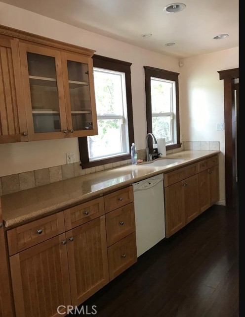 Detailed view of newer, shaker cabinets with glass doors on uppers.