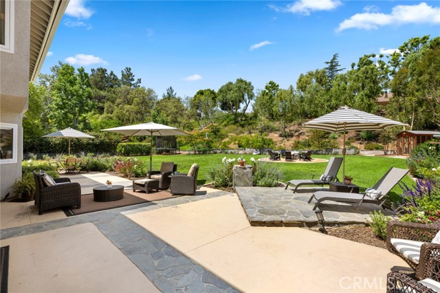 One of the most incredible park-like backyards you will come to find with the ultimate in privacy and serenity! Set high in the hills of Yorba Linda on one of the most desirable cul-de-sac streets offering a serene natural setting on over a sprawling half acre of land. Drive up to picture perfect appeal and open the doors to a Hallmark moment. Transitional farmhouse feel with gorgeous white oak flooring, striking wrought iron staircase with natural white oak handrails, designer 100% wool carpet, neutral paint, vaulted ceiling and completely open light and bright living. Large updated open kitchen boasts a wall of windows bringing the outdoors in, plentiful meal prep counter space, stainless appliances and sleek granite countertops. Casual dining nook and family room are warmed by white brick fireplace with French doors opening to your very own backyard escape. Expansive primary suite is entered through double doors offering bedroom-sized retreat or 5th bedroom, updated bath with separate tub & shower, dual vanities & walk-in closet. Three additional bedrooms each offer their own personality, with one of the bedrooms down and one bonus-room sized bedroom upstairs with high beamed vaulted ceiling! Outdoors is where the real fun begins! It is an irreplaceable Southern feel with beautiful trees, fragrant flowers, an endless lush green lawn including your very own chicken coop. Family and friends will want to spend every night gathering under the stars by the fire pit telling their favorite stories. This is a yard that is a Unicorn and will create priceless and unforgettable memories and experiences. Newer windows and doors, whole house reverse osmosis water system, contemporary light fixtures, numerous skylights, plus a 3-car garage wired for EV and expanded driveway completes the perfect picture. Completed architectural plans for backyard casita, California room and pool & spa. Just a short stroll to San Antonio Park and attends Travis Ranch K-8 and Yorba Linda High School.