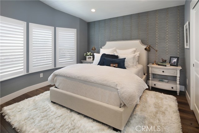 Large secondary bedroom with loads of light through multiple windows including plantation shutters.