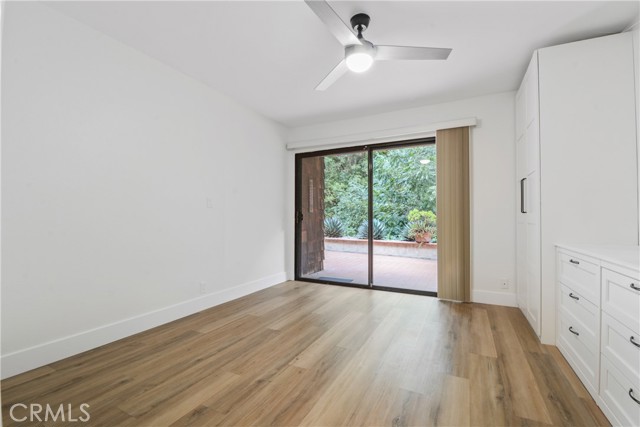 Downstairs bedroom that opens to the tranquil backyard patio with peaceful tree view.