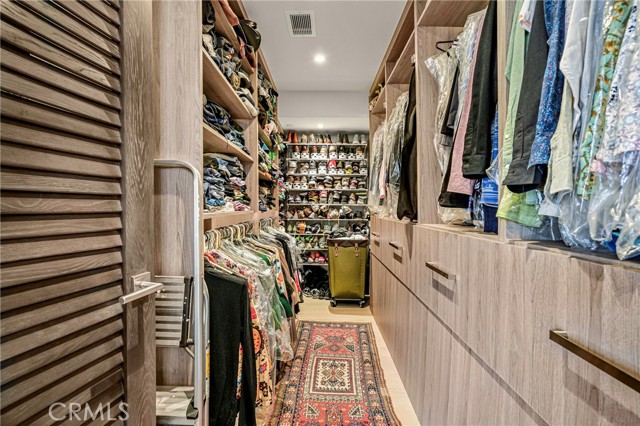 Large, walk-in primary suite closet. Custom built-in storage & shelving.