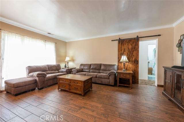 Living room facing barn door leading to hall