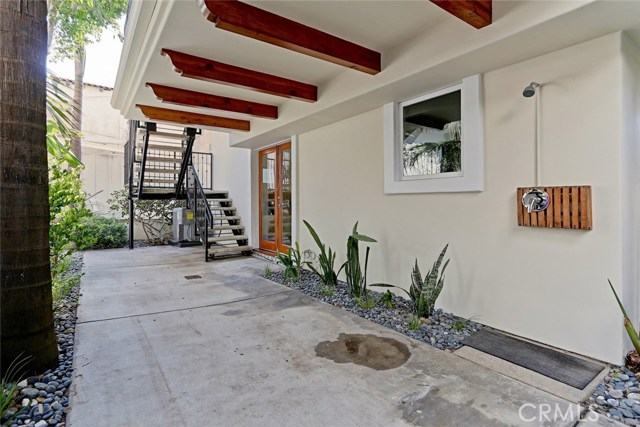 rear back yard with shower for to wash off the sand from the beach. this can be gated, stairs lead up to each level. Air conditioner unit under staircase