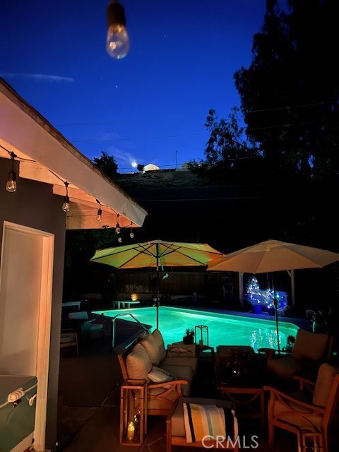 A view of the pool at night, showing how it lights up in the backyard