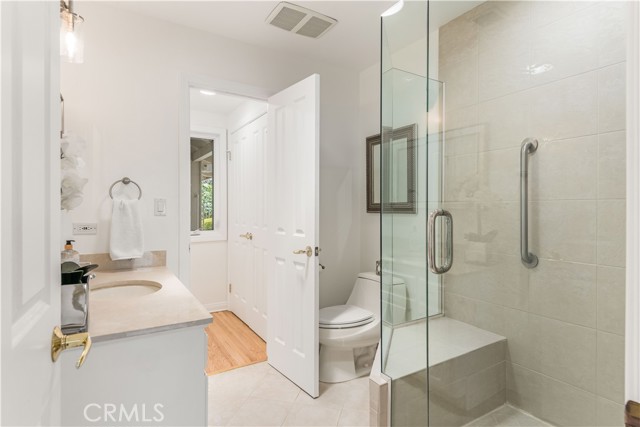 Bathroom 2 has 2 entrance/exits and a tiled walk-in shower with sit down bench.