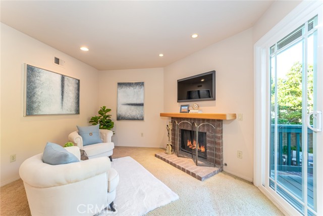 Sitting area with fireplace opens up to a peaceful balcony