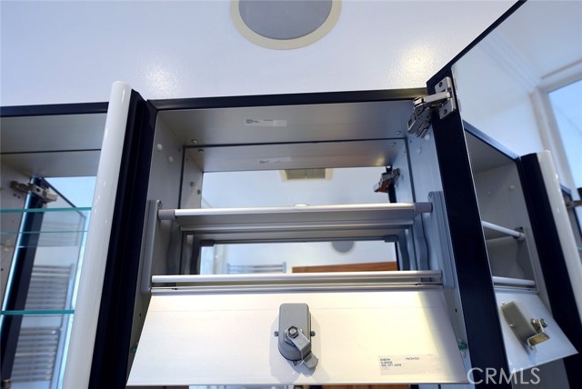 Lockable medicine cabinet within center Robern cabinet; Polk Audio speaker top center