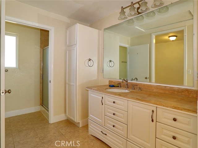Bathroom Vanity and Linen Cabinet, Walk in Shower, Water Conservation toilet opposite the shower.