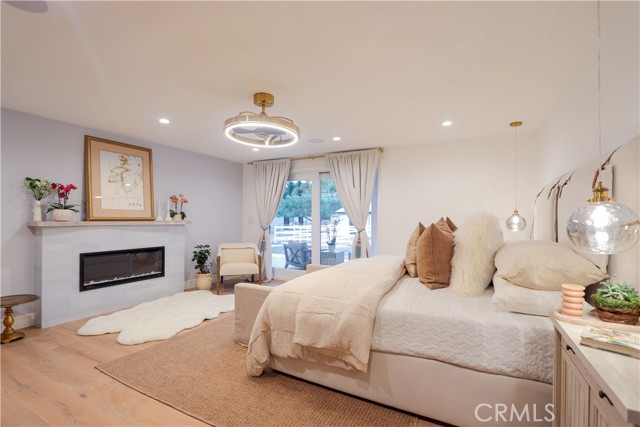 The luxurious primary suite is a private sanctuary featuring a fireplace, expansive proportions, and direct access to the oversized patio for seamless indoor-outdoor living.