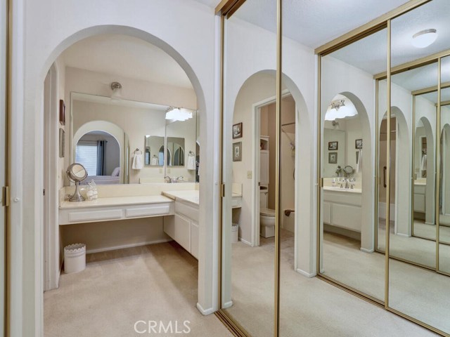 Double mirrored wardrobes and primary vanity area