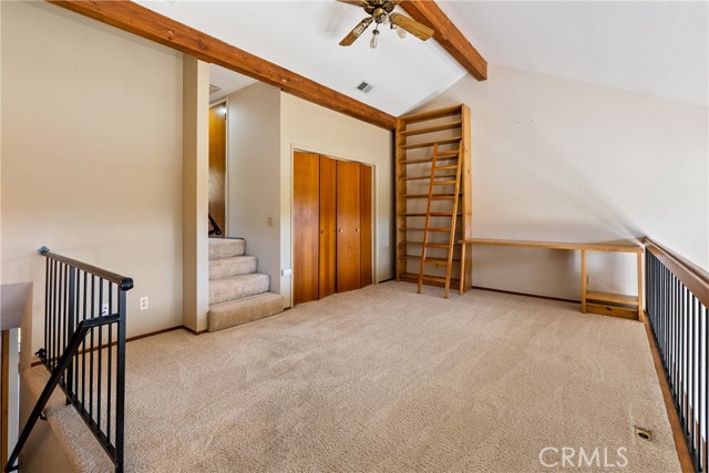 The loft has closet space, floor-to-ceiling shelving, and a built-in desk!