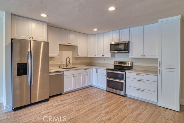 Newly remodeled kitchen with shaker cabinets, stainless steel appliances and quartz counters.