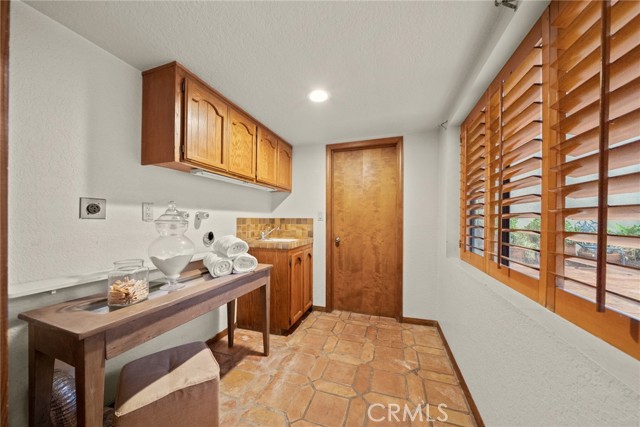 Large laundry room w sink and door to utility room