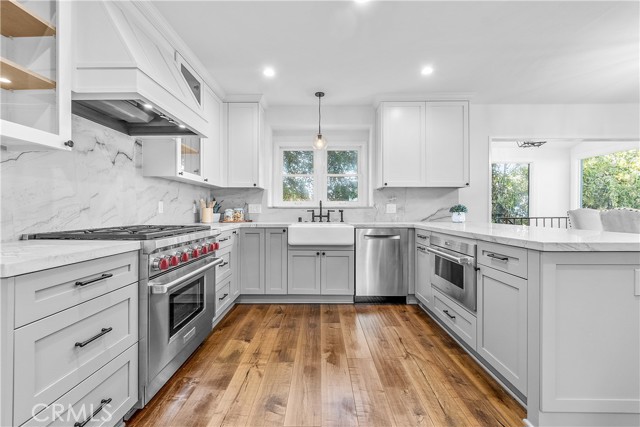 An enviable kitchen featuring top of the line Wolf appliances, Sub-Zero refrigerator, ample quartzite countertops, and gorgeous solid wood cabinetry.