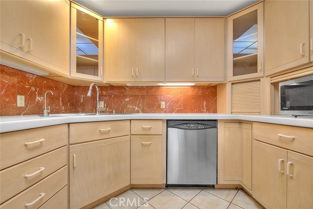 Beautifully Remodeled Kitchen With Wood Cabinets.  Overhead Glass Door Cabinets.  Marble Backsplash.  Corner Storage With Rollup Door.  Faucet With Pullout Head Activated By Motion Sensor.  Filtered Water Dispenser.  Stainless Steel Dishwasher