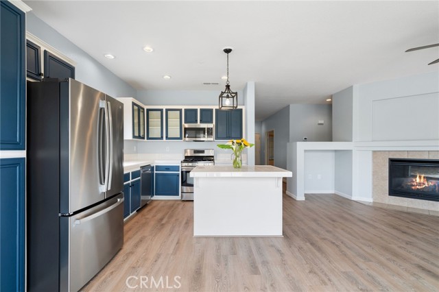 Updated island kitchen with stainless refrigerator opens into the large family room