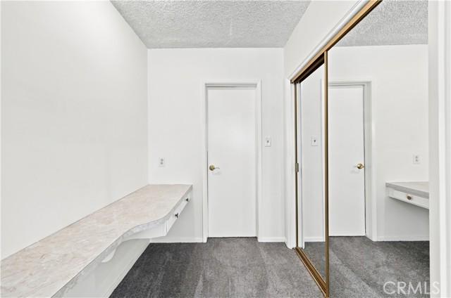 Entry to primary bathroom with one of the closets and makeup countertop or can be used for office space Entry to primary bathroom with one of the closets and makeup countertop or can be used for office space