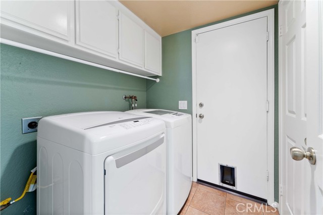 Laundry with door to the garage. Garage has epoxy flooring and finished walls.