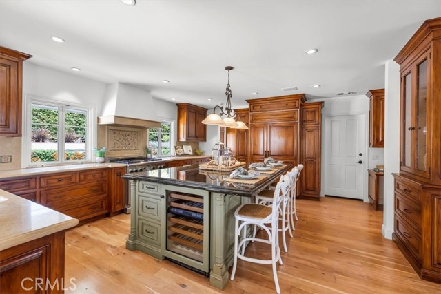 Beyond the kitchen is the 4th Bedroom Suite in the left corner, access to the garage in the center, built-in desk and Laundry Room to the Right, with Sink and geometric Window with pretty views.