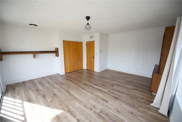 View of the second corner bedroom.  Doors are to the closet area and the small door on the right leads out to the hallway. Built-in on the right adds additional storage.