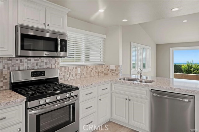 Equipped with stainless appliances, including a 5 burner gas range, microwave, dishwasher and side-by-side refrigerator. Also, recessed lighting, plantation shutters and cool color paint palette.
