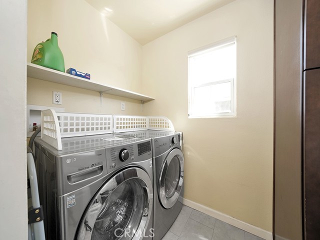 Laundry room conveniently situated next to kitchen with door leading to backyard.