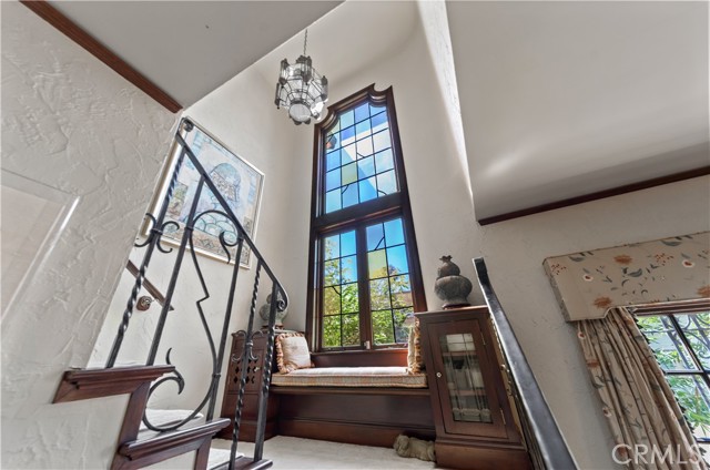 Custom built-ins and stained glass window leads to 2nd level