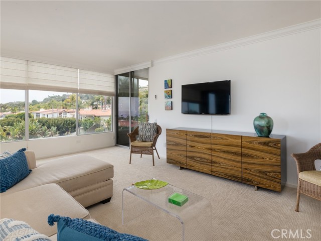 Living room with windows all the way across and door to second large balcony.