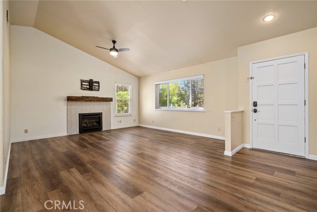 Enter into the living room where your eyes are drawn upward with the vaulted ceilings and out the large window to the front yard.