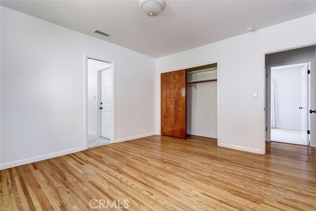 Primary suite with hardwood floors and a lovely remodeled and spacious bath.