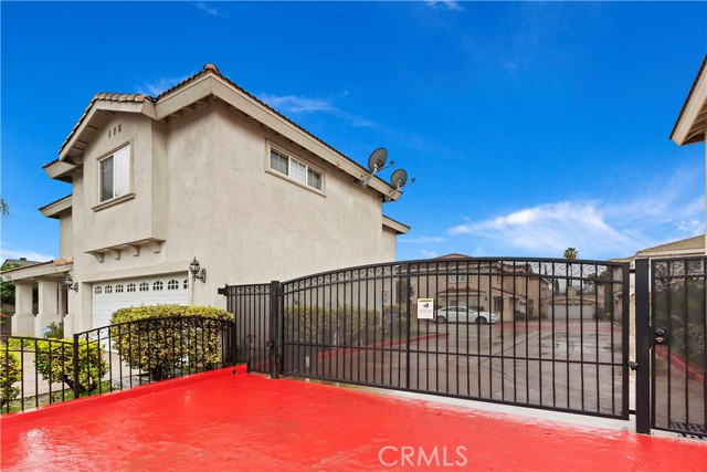 Front of home with gate access to extra parking space.