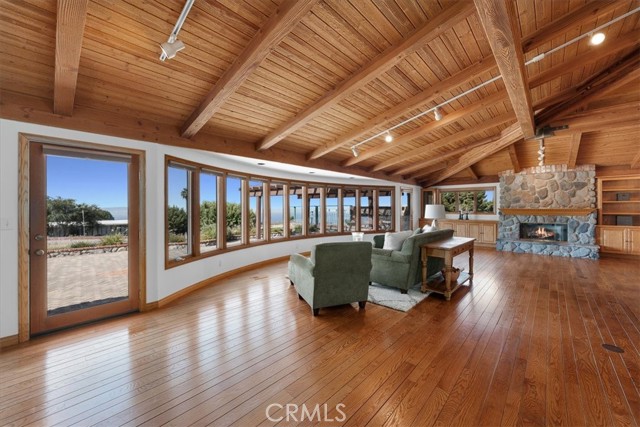 Living Room featuring expansive windows, providing abundant, natural light, along with sunrise and ocean views.