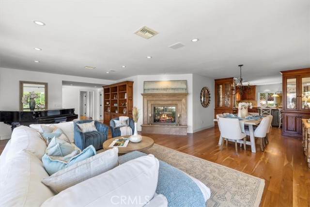 Open Living Room and Dining Room with Double-Sided Fireplace, Refinished Hardwood Flooring.