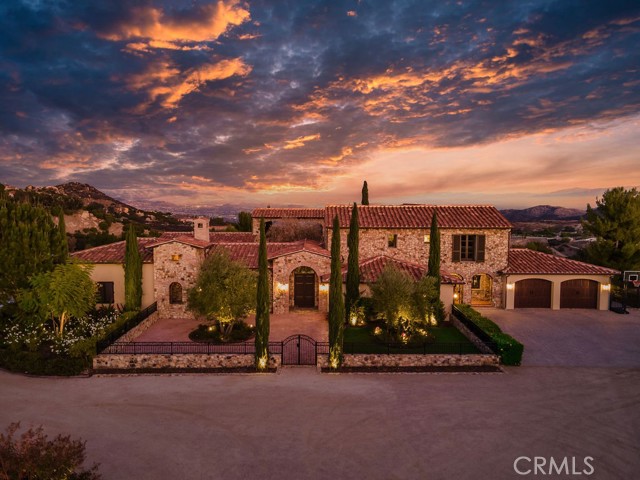 Million dollar breathtaking views from this Italian inspired farmhouse estate! Boasting 5 bedrooms, 7 bathrooms, over 11 lush fully developed acres with a massive 1/4 acre 15' deep pond complete with a full kitchen and plenty of room to entertain family and friends!  Custom hardwood interior doors, cabinets and trim work, imported Italian windows and handmade Italian floors are but a taste of the authenticity this estate brings to life!  Locally sourced stone laces the interior and exterior walls, a gorgeous foyer, bold staircase, formal living room with cozy fireplace, floor to ceiling custom brickwork in the formal dining room, and a family room that feeds you with stunning views of the Murrieta/Temecula Valley and surrounding mountain ranges!  Hold on, it gets even better!   Enjoy top of the line appliances throughout, a butlers pantry, wine closet, vaulted barrel ceiling in the breakfast nook, fresh paint inside and out, new HVAC systems, motion activated recirculating hot water system throughout, plumbing auto leak detector, auto-open heated toilets in most bathrooms with bidet, new tankless water heaters,  water softener w/purification to most wet areas and a Colorado V-NET smart home system. Craft room/office with built ins and walk in closet.  The lower level offers a guest bedroom with on suite bath and private patio, master bedroom with fireplace and massive his/hers bathroom including your own patio to soak in the valley/mountain views.  Rounding out the downstairs enjoy your own private 21 person, 3 tiered movie theatre with state of the art audio and visual equipment! Upstairs offers a great room w/ kitchenette and stackable washer/dryer, 3 bedrooms with on suite baths and princess balconies.  If outdoor living is your thing this surely won't disappoint with multiple seating areas and walking trails, a 6 hole chipping course, 800 low voltage lights covering the entire property, 1/4 acre self sufficient pond stocked with fish boasting two waterslides a bridge and jumping rock, beach entry on one side of the pond, full kitchen with commercial grade refrigerators located right off the pond, 1/2 bath in the backyard, playset for children, two story tree house overlooking the valley floor, 8 campsites with charcoal BBQs, amphitheater, pavilion, fully irrigated with drip and sprinklers, and of course 120 paid off solar panels ready to power your home!  When it comes to quality and amenities this estate spares nothing!!!