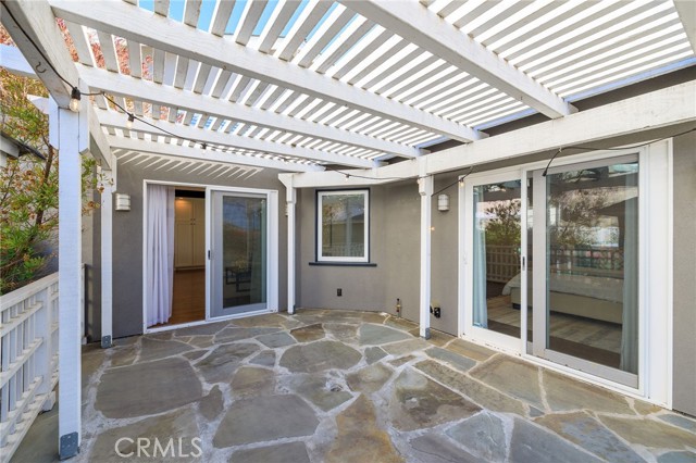 Rear stone patio with pergola